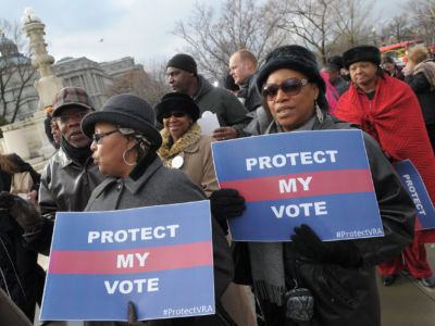 Activists hold pro-voting rights placards outside the US Supreme Court in Washington, DC, on February 27, 2013, as the Court prepared to hear Shelby County vs Holder, which reversed some important provisions of the 1965 Voting Rights Act.