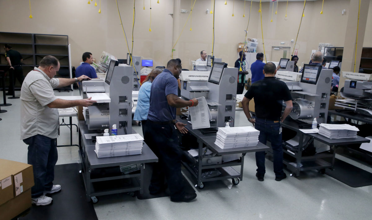 Elections staff load ballots into machines as recounting begins at the Broward County Supervisor of Elections Office on November 11, 2018 in Lauderhill, Florida.