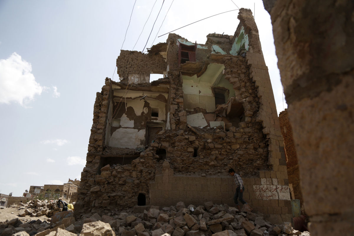 A boy walks by a house destroyed in an airstrike carried out by a Saudi-led coalition warplane in Sana'a, Yemen, September 19, 2018.