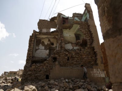 A boy walks by a house destroyed in an airstrike carried out by a Saudi-led coalition warplane in Sana'a, Yemen, September 19, 2018.
