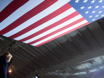 President Donald Trump speaks beneath a US flag during a campaign rally at Columbia Regional Airport in Columbia, Missouri, November 1, 2018.