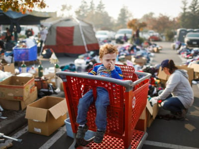 Evacuee Josaiah Darby, 3, waits in a shopping cart as his mother, Autumn Darby, looks through items at a Target parking lot on November 18, 2018. Autumn and her son Josaiah lost their home after the Camp Fire tore through Paradise, California. Tens of thousands have been left homeless after the fire burned through the town and other communities east of Chico.