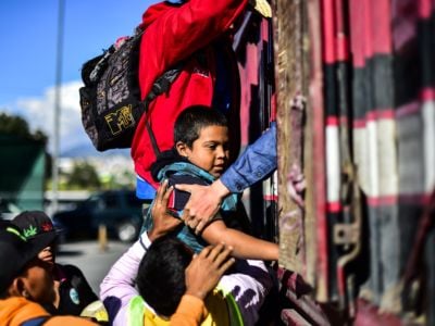 A boy receives help to get into the back of a truck as migrants from poor Central American countries -mostly Hondurans- move toward the United States in hopes of a better life or to escape violence are offered a ride along the Mexico City-Puebla highway in San Marcos, Mexico, on November 5, 2018.