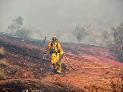 San Ramon Valley Fire Department firefighter Casey Good works to stop the Woolsey Fire from reaching homes on Dequincy Court in West Hills, California, on Sunday, November 11, 2018.