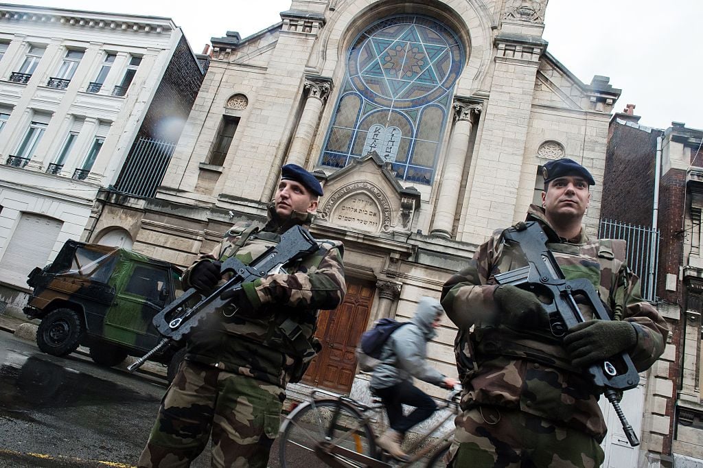 French soldiers stand guard in front of the entrance of a synagogue in Lille, northern France, on January 13, 2015. France announced on January 12 the unprecedented deployment of 10,000 soldiers to boost security, including at Jewish schools, a day after almost four million people marched in solidarity with the victims of the Charlie Hebdo massacre.