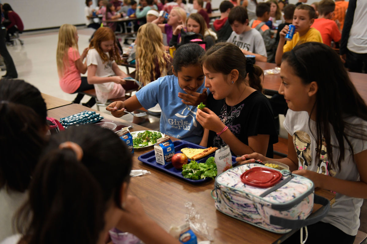 Centennial Middle School 6th grader Diana Pacheco talking with her friend Emily Dazquez. Both girls have fresh salad from one of the two salad bars at the school during lunch in the Montrose County School district on September 1, 2016, in Montrose, Colorado.