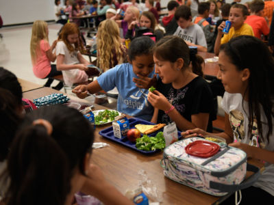 Centennial Middle School 6th grader Diana Pacheco talking with her friend Emily Dazquez. Both girls have fresh salad from one of the two salad bars at the school during lunch in the Montrose County School district on September 1, 2016, in Montrose, Colorado.