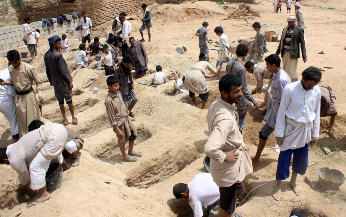 Yemenis dig graves for children, who where killed when their bus was hit during a Saudi-led coalition airstrike in Saada, on August 10, 2018.