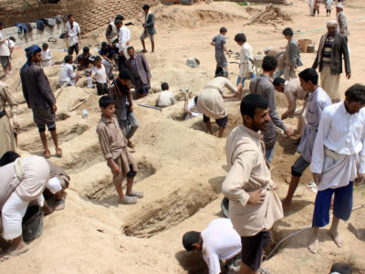 Yemenis dig graves for children, who where killed when their bus was hit during a Saudi-led coalition airstrike in Saada, on August 10, 2018.