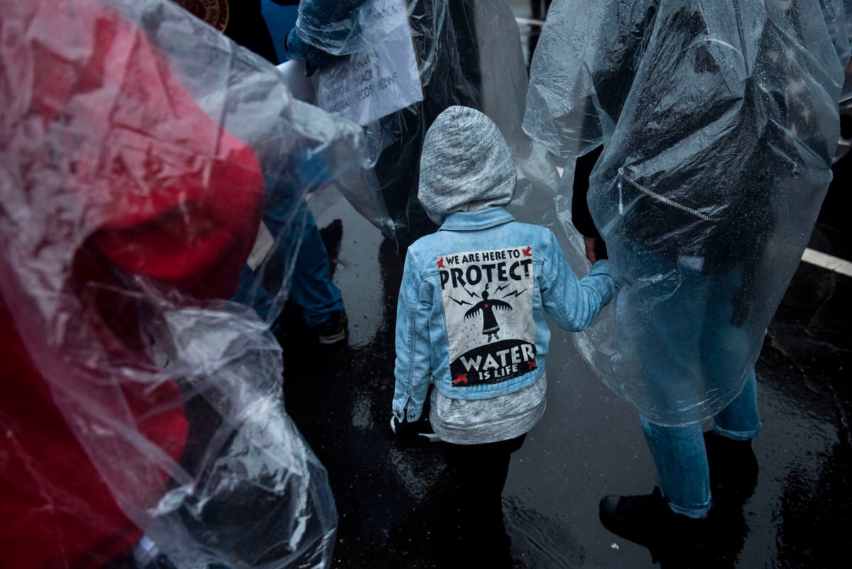 Activists wait to march outside the US Army Corps of Engineers to protest the Keystone XL Pipeline and rally for Native American rights during the Native Nations Rise march on March 10, 2017, in Washington, DC.