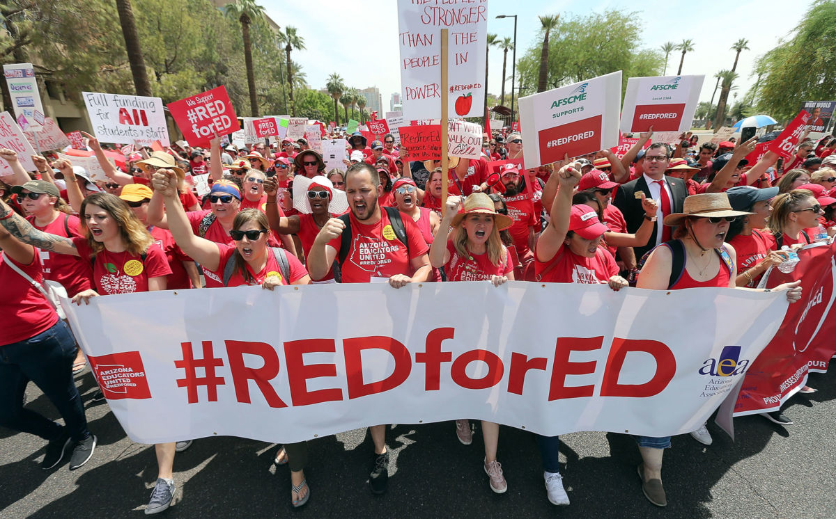 Thousands of Arizona teachers march through downtown Phoenix on their way to the State Capitol as part of a rally for the #REDforED movement on April 26, 2018, in Phoenix, Arizona.