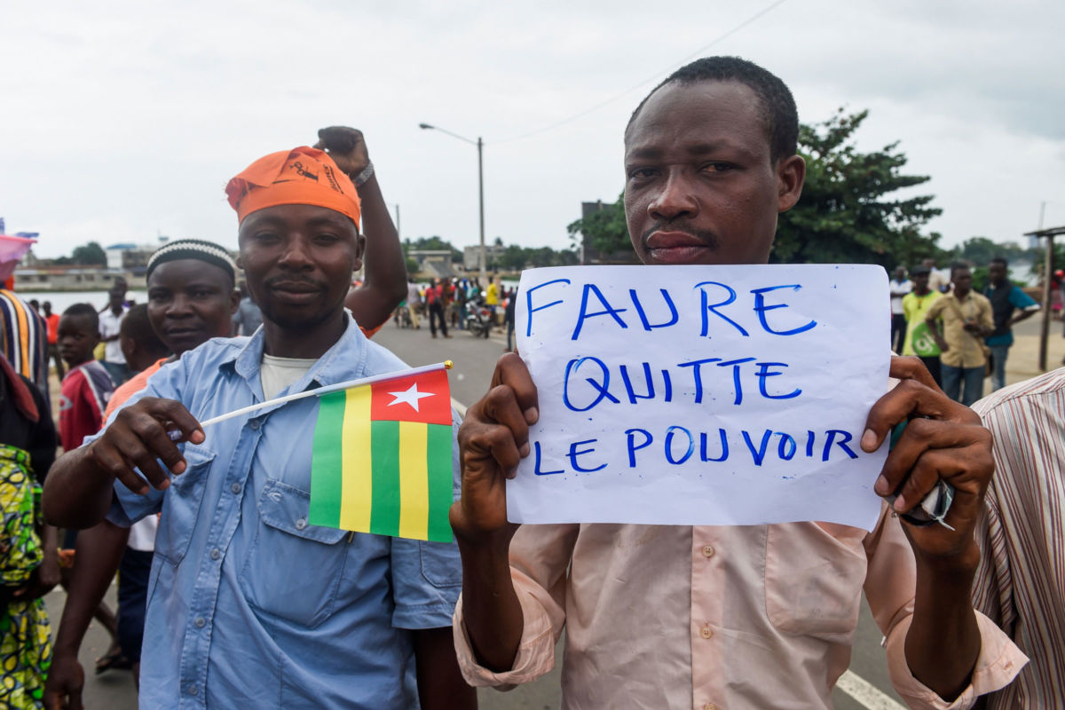 Protesters march and chant slogans during an anti-government protest led by a coalition of opposition parties in Lome, on September 7, 2017. Huge crowds turned out in Togo's capital for the second day running to demand political reform, in the largest opposition protests against President Faure Gnassingbe's regime. The placard reads 'Faure, resign'.