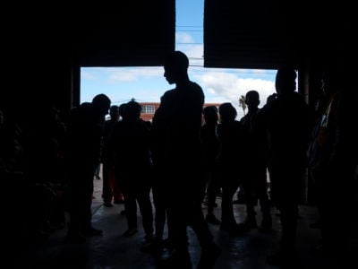 Central American migrants who travelled in a caravan to the Mexico-US border gather at the entrance of a temporary shelter in downtown Tijuana, Baja California State, Mexico, on December 17, 2018.