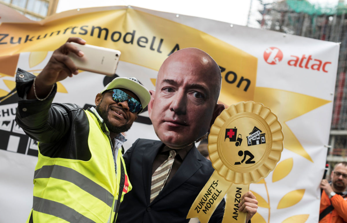 An Amazon warehouse worker shoots a selfie with an activist dressed as Amazon CEO Jeff Bezos during a protest in Berlin, April 2018.