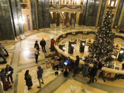 Protesters sit in the Capitol Rotunda waiting to hear on legislation in a special session called by Republicans on December 4, 2018, in Madison, Wisconsin. Wisconsin Republicans passed a series of proposals that will weaken the authority of Governor-elect Tony Evers and incoming Democratic Attorney General Josh Kaul.