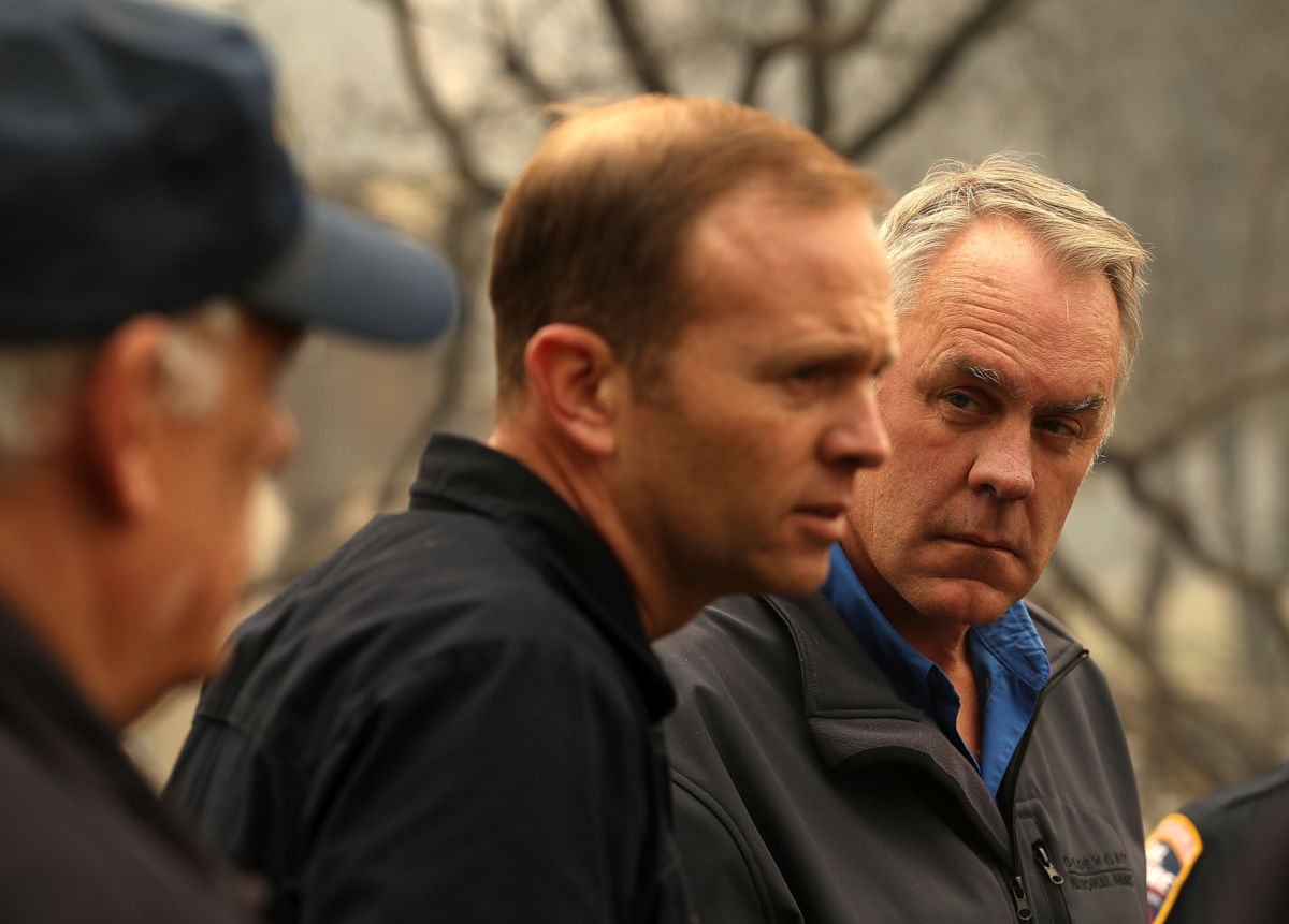 US Secretary of the Interior Ryan Zinke looks on as FEMA Adminstrator Brock Long speaks during a tour of a school burned by the Camp Fire on November 14, 2018, in Paradise, California.