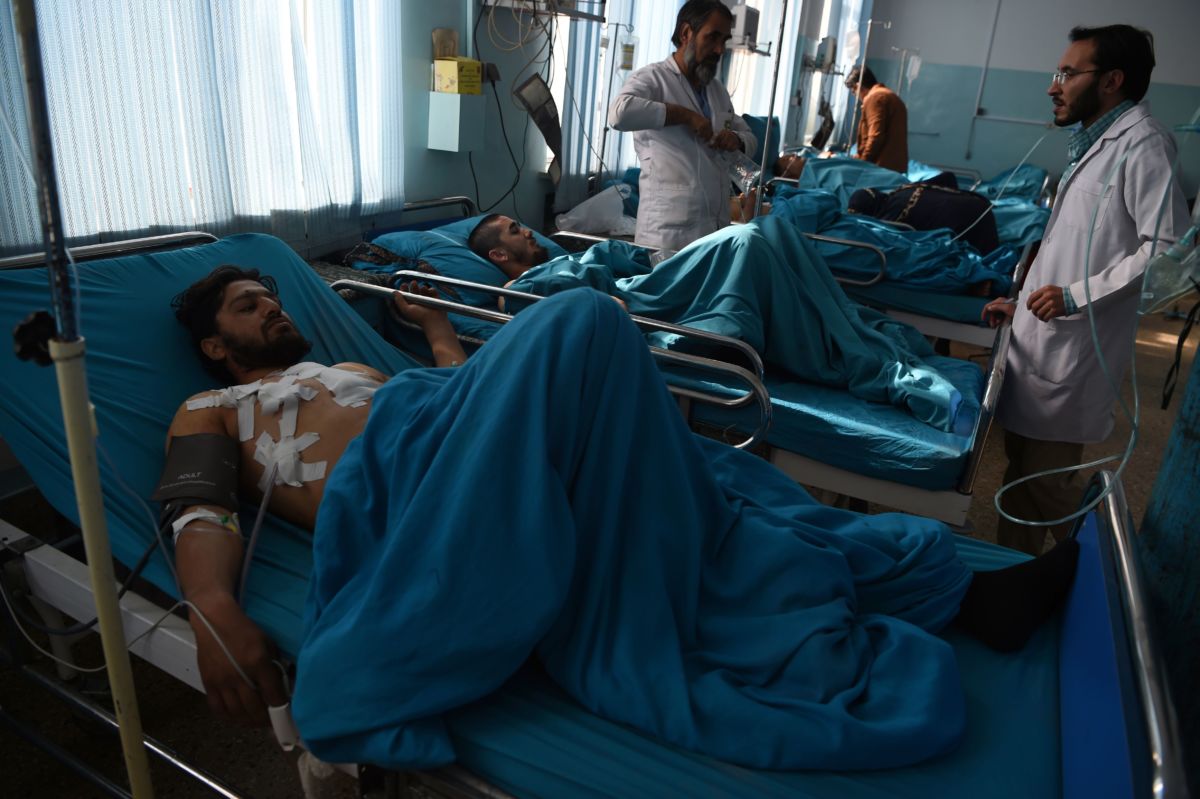 Wounded Afghan men receive treatment at the Wazir Akbar Khan hospital a day after a suicide attack on a religious celebration in Kabul on November 21, 2018.