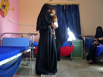 A Yemeni mother holds her malnourished child as they wait for treatments in a medical center in the village of Al Mutaynah in the Tuhayta province in western Yemen on November 29, 2018.