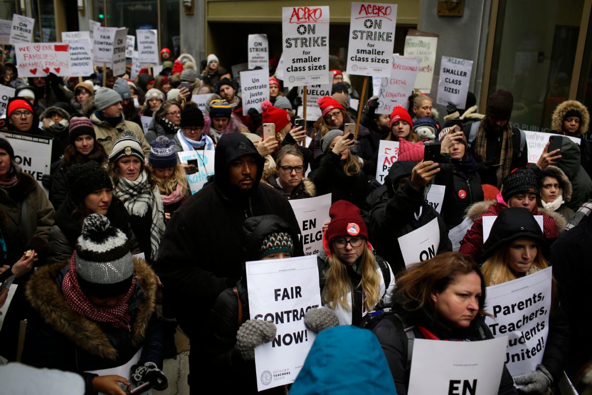 Educators from the Acero charter school network hold signs as they protest during a strike outside Chicago Public Schools headquarters on December 5, 2018, in Chicago, Illinois.