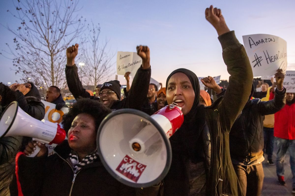 Demonstrators shout slogans and hold placards during a protest at the Amazon fulfillment center in Shakopee, Minnesota, on December 14, 2018.