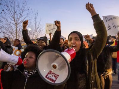 Demonstrators shout slogans and hold placards during a protest at the Amazon fulfillment center in Shakopee, Minnesota, on December 14, 2018.