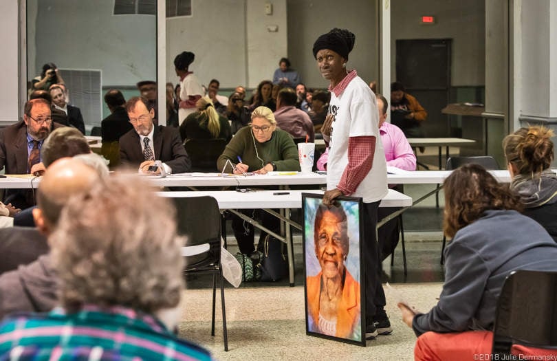 Rita Copper, a resident of St. James Parish, holding a photo of a deceased friend who died of cancer. “We are already plagued with plants. They are killing us,” she said while speaking out against Formosa’s plant.