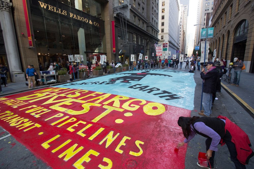 Guerrilla street painting against fossil fuel pipeline investment outside Wells Fargo World Headquarters in San Francisco, November 6, 2017.