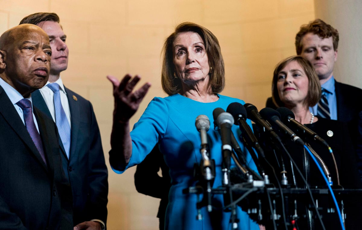 Then House Minority Leader Nancy Pelosi, surrounded by members of her caucus, speaks on Capitol Hill in Washington, DC, on November 28, 2018.