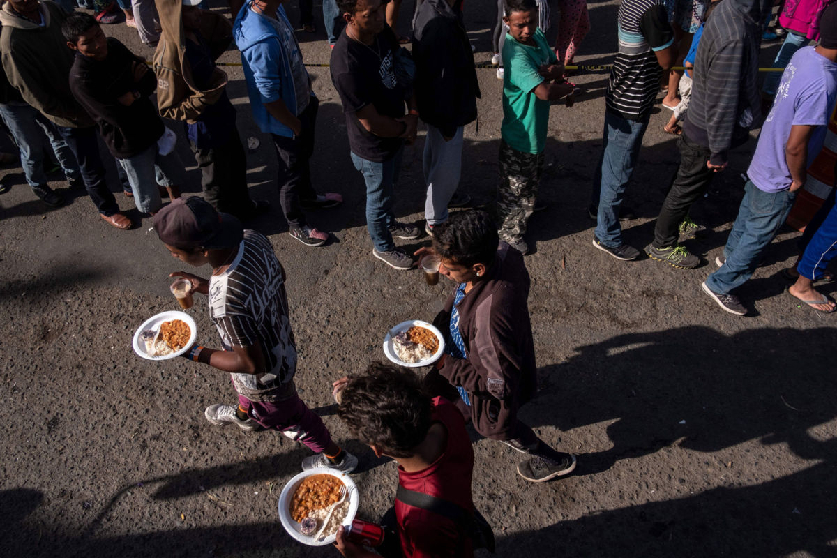 A group of Central American migrants line up for food outside a temporary shelter at the US-Mexico border in Tijuana, Mexico, on November 23, 2018.