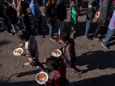 A group of Central American migrants line up for food outside a temporary shelter at the US-Mexico border in Tijuana, Mexico, on November 23, 2018.