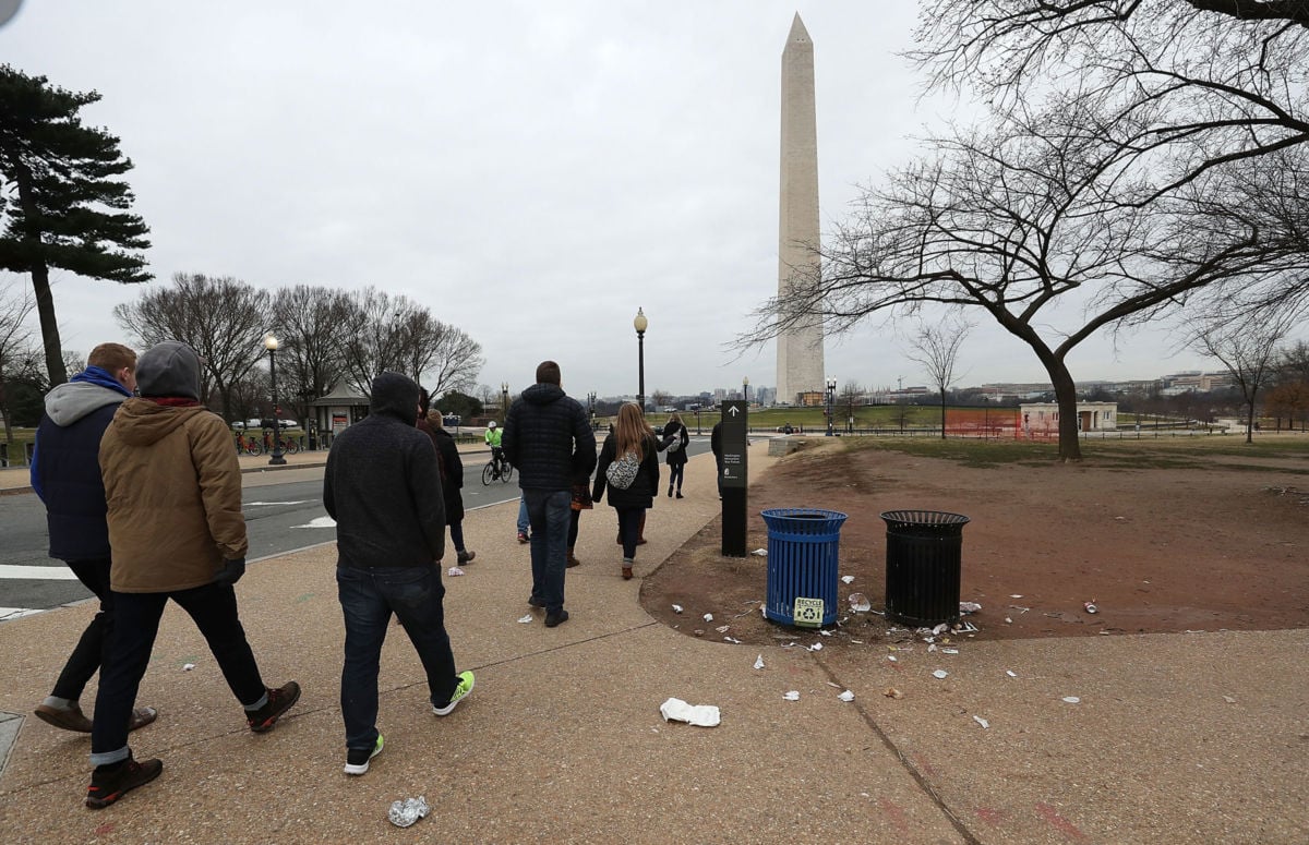 Tourists walk past trash laying on the ground of the National Mall as the partial shutdown of the US government goes into the 12th day, on January 2, 2019, in Washington, DC.