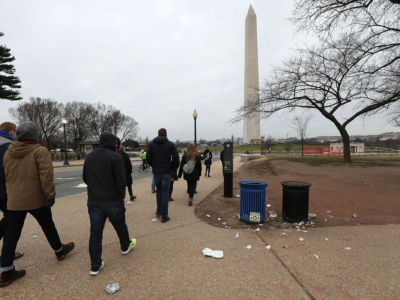 Tourists walk past trash laying on the ground of the National Mall as the partial shutdown of the US government goes into the 12th day, on January 2, 2019, in Washington, DC.