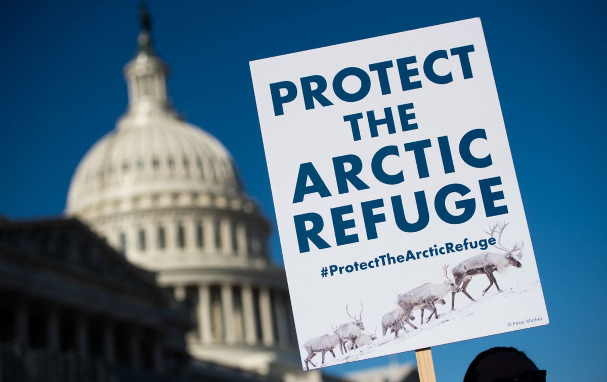 A demonstrator holds a sign against drilling in the Arctic Refuge on the 58th anniversary of the Arctic National Wildlife Refuge, during a press conference outside the US Capitol in Washington, DC, December 11, 2018. Under Trump, oil drilling has taken priority over essential services like trash pickup in national parks.