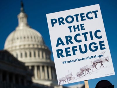 A demonstrator holds a sign against drilling in the Arctic Refuge on the 58th anniversary of the Arctic National Wildlife Refuge, during a press conference outside the US Capitol in Washington, DC, December 11, 2018. Under Trump, oil drilling has taken priority over essential services like trash pickup in national parks.