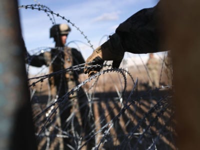 Marines install razor wire as seen through the US-Mexico border fence on December 2, 2018, from Tijuana, Mexico.