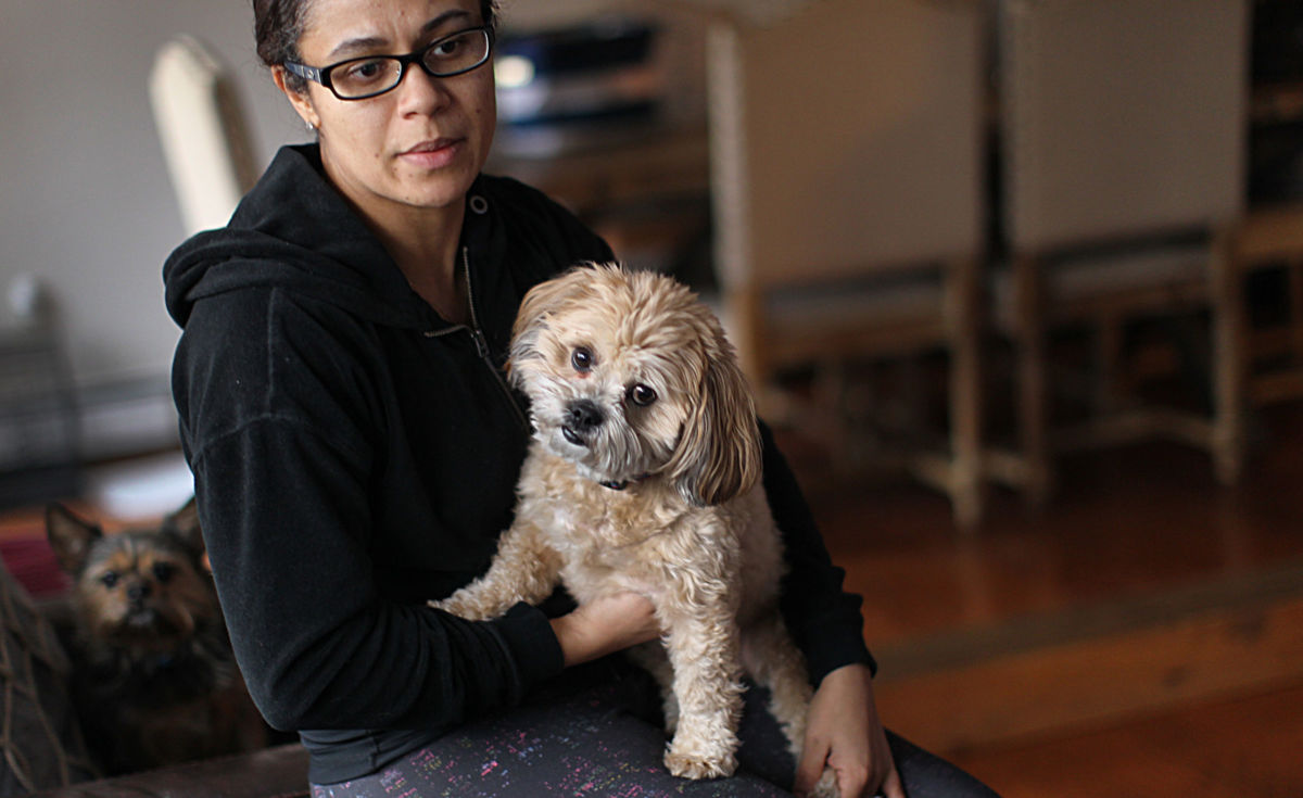Transportation Security Administration (TSA) employee Rita Silva-Martins holds her dog, Mochi, in Natick, Massachusetts, on January 10, 2019. Because federal funding for the TSA lapsed on December 22, her paycheck is in danger. Unless a deal is brokered soon to reopen the government, her finances are on a collision course with President Trump's fight for $5 billion to build a wall on the southern border.