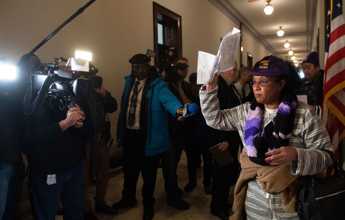Mahasin Mohamed, a furloughed contract worker who works at the Smithsonian and has not been paid during the partial government shutdown, holds an unpaid electric bill to present to Senate Majority Leader Mitch McConnell's office on Capitol Hill in Washington, DC, January 16, 2019.