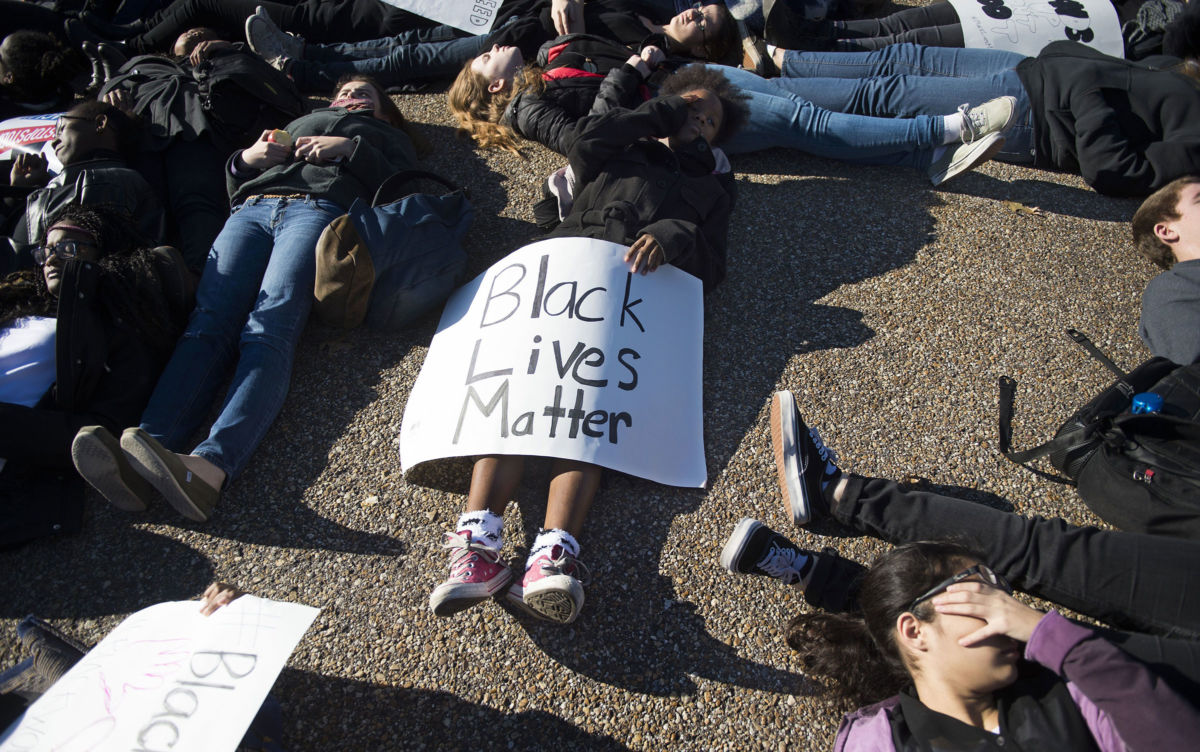 Students from School Without Walls High School march after performing a die-in on Pennsylvania Avenue in front of the White House in Washington, DC, December 17, 2014, demonstrating against police violence and human rights.