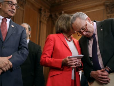 Senate Minority Leader Charles Schumer and Speaker of the House Nancy Pelosi talk during an event to introduce the Raise The Wage Act with House Education and Labor Chairman Bobby Scott in the Rayburn Room at the US Capitol, January 16, 2019, in Washington, DC.