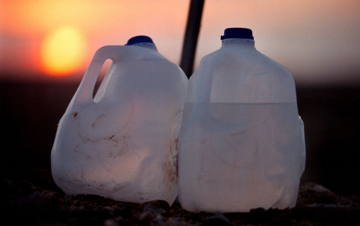 The sun rises behind bottles at a water station for migrants near the US-Mexico border in the Yuha Desert west of Calexico, California.