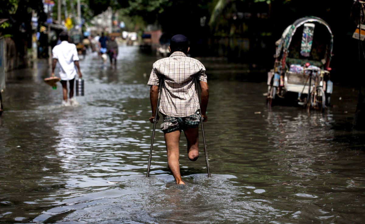 A disabled man travels through a flooded area of Chittagong, Bangladesh. The city is facing unprecedented flooding due to rising sea levels.