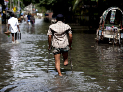 A disabled man travels through a flooded area of Chittagong, Bangladesh. The city is facing unprecedented flooding due to rising sea levels.