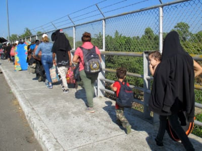 Central American migrants and refugees cross a bridge from Guatemala to Mexico in January 2019 to apply for humanitarian visas.