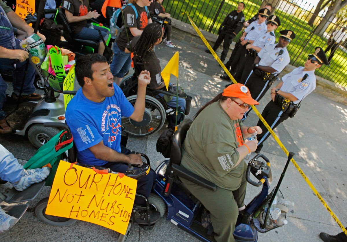 Protestors from ADAPT, a grassroots community that organizes disability rights activists to engage in nonviolent direct action, block the sidewalk along the north side of the White House, September 20, 2010, in Washington, DC.