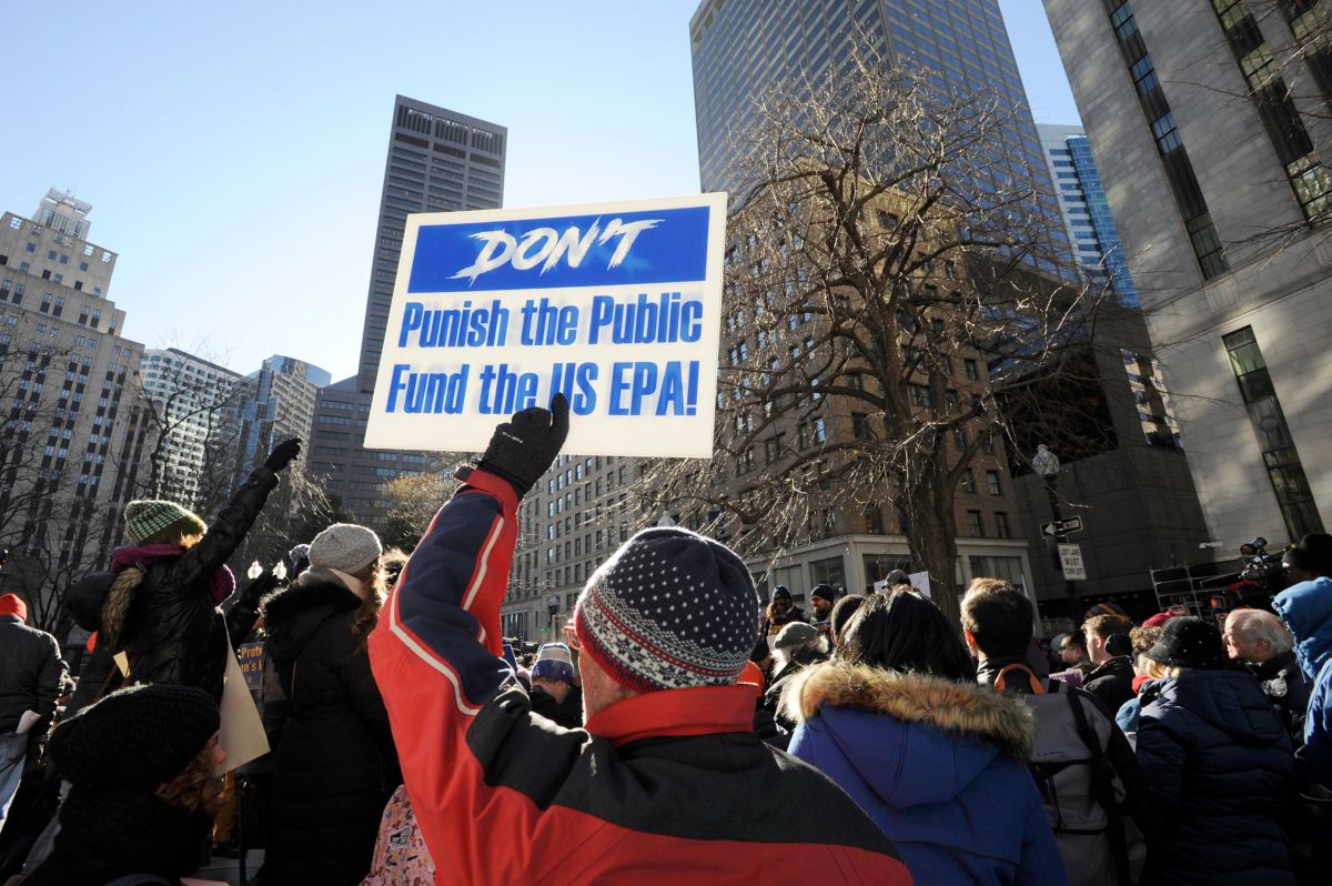 An EPA employee holds a sign during a protest rally by government workers and concerned citizens against the government shutdown on Friday, January 11, 2019, at Post Office Square near the Federal building in Boston, Massachusetts.