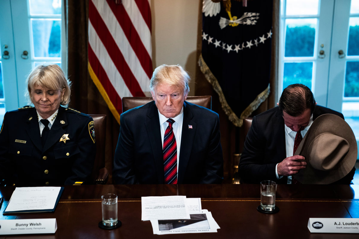 President Trump bows his head during a prayer as he participates in a roundtable discussion on border security with state, local and community leaders in the Cabinet Room on the 21st day of the partial government shutdown at the White House on Friday, January 11, 2019, in Washington, DC.