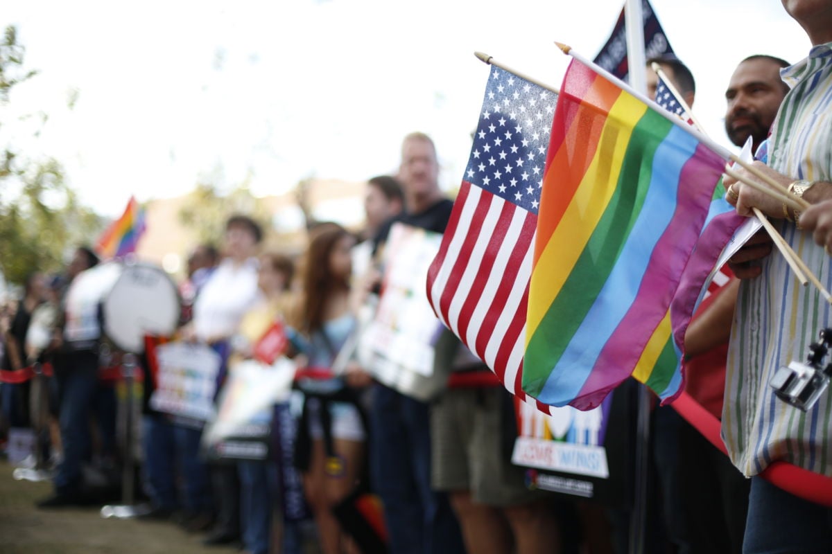 A US flag and a pride rainbow flag overlap in the crowd during a marriage equality rally in West Hollywood, California, celebrating the Supreme Court's ruling on June 26, 2015.