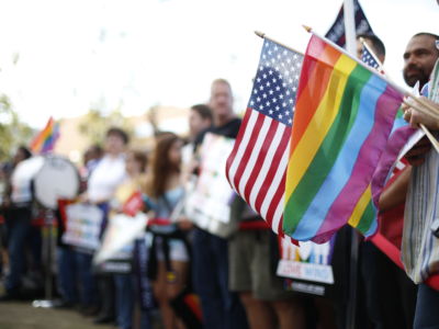 A US flag and a pride rainbow flag overlap in the crowd during a marriage equality rally in West Hollywood, California, celebrating the Supreme Court's ruling on June 26, 2015.