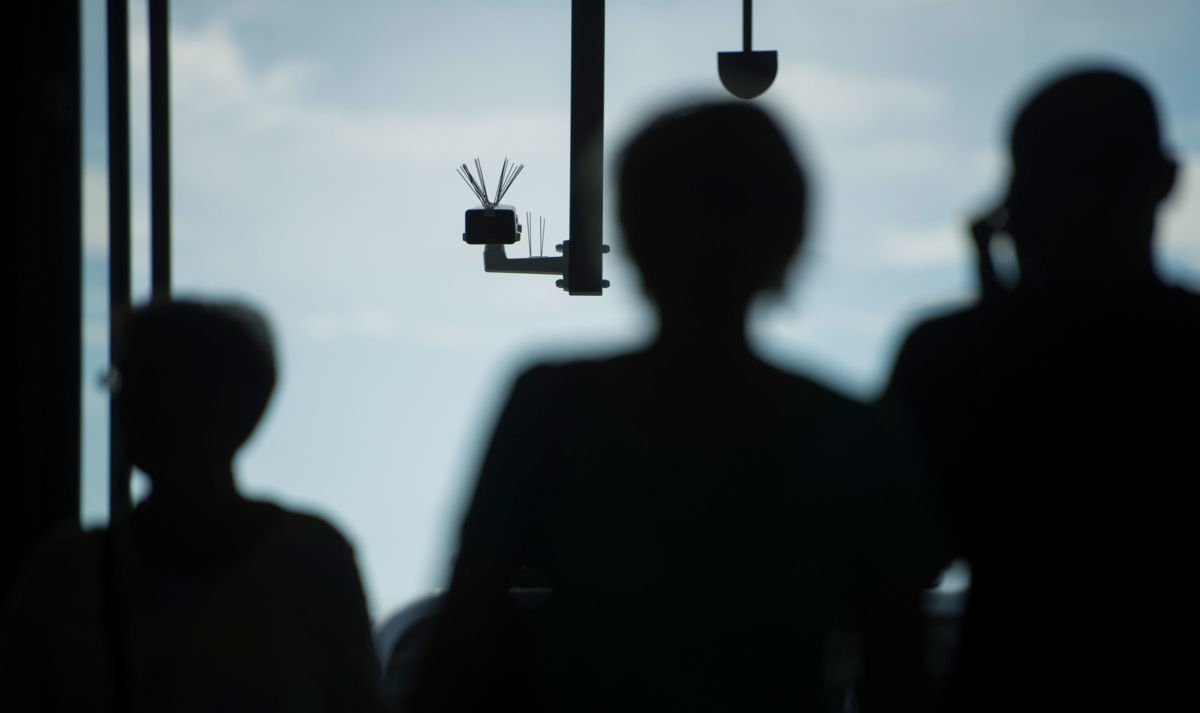 Passersby walk under a surveillance camera which is part of a facial recognition technology test at Berlin Suedkreuz station on August 3, 2017, in Berlin, Germany.