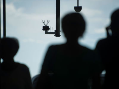 Passersby walk under a surveillance camera which is part of a facial recognition technology test at Berlin Suedkreuz station on August 3, 2017, in Berlin, Germany.